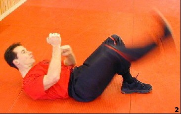 Wing Tsun Exercise 75, Fig. 2 - Now he moves down his leg to apply a cutting move